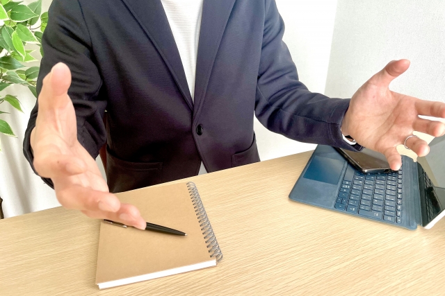 手を広げながら話す男性