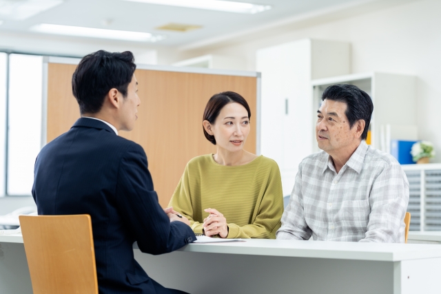 ビジネスマンと会話する夫婦
