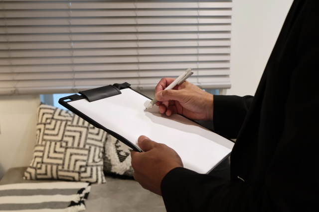 メモを取りながら室内をチェックしている男性